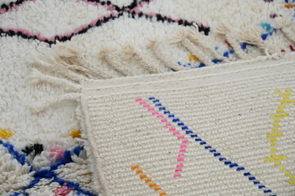 Cream-colored moroccan handmade traditional azilal rug with vibrant hand-knotted geometric patterns by decorbites