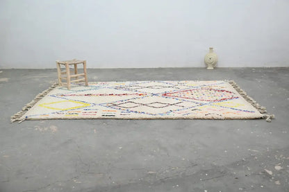 Cream-colored DecorBites™ moroccan handmade traditional azilal rug with intricate multicolored geometric patterns and fringed edges