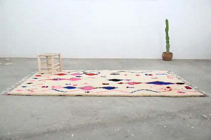 Cream-colored moroccan handmade traditional azilal rug with vibrant pink blue and black geometric patterns 273 x 151 cm