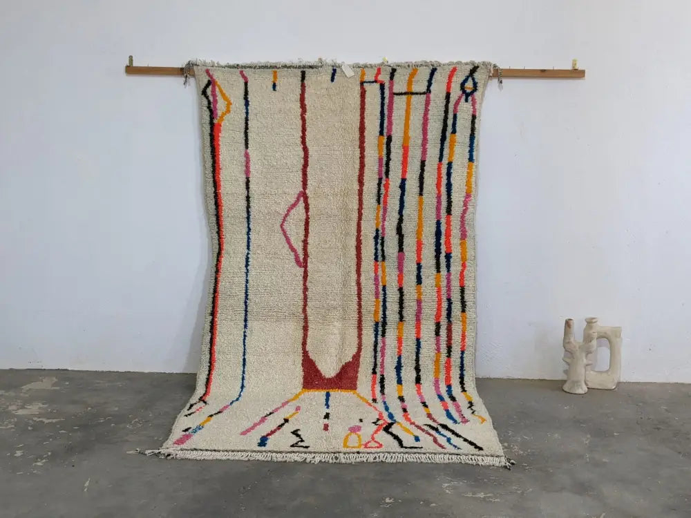 Beige moroccan handmade azilal rug with colorful vertical stripes and central abstract design in pure natural wool