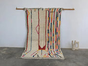 Beige moroccan handmade azilal rug with colorful vertical stripes and central abstract design in pure natural wool