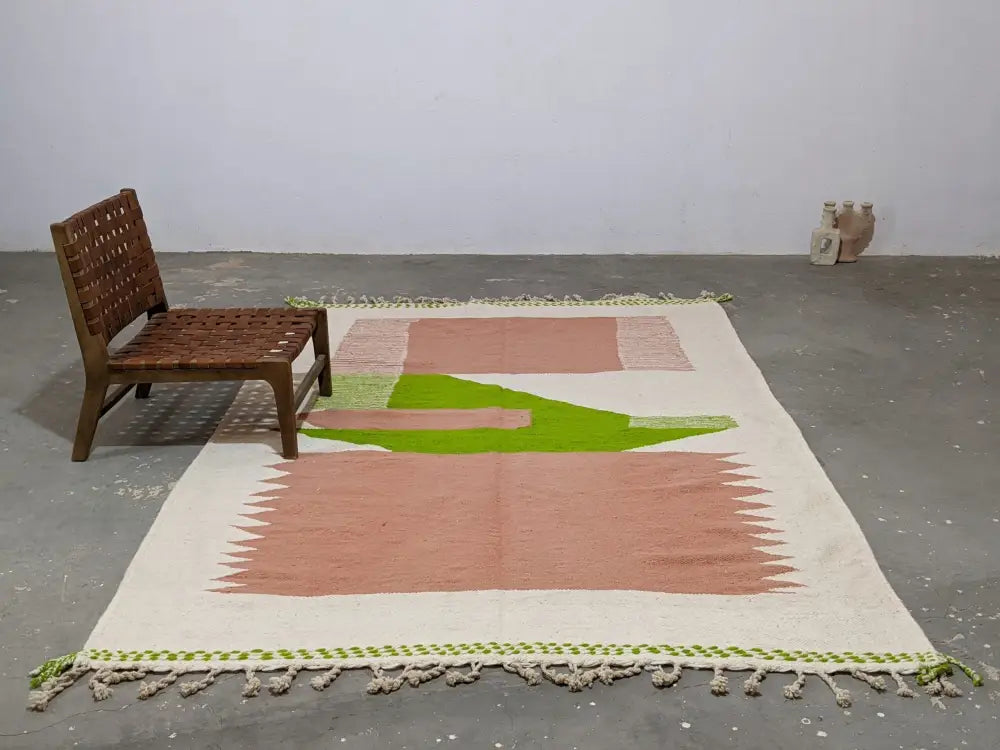 Cream-colored moroccan handmade traditional azilal rug with soft pink and lime green geometric patterns and tassel fringe