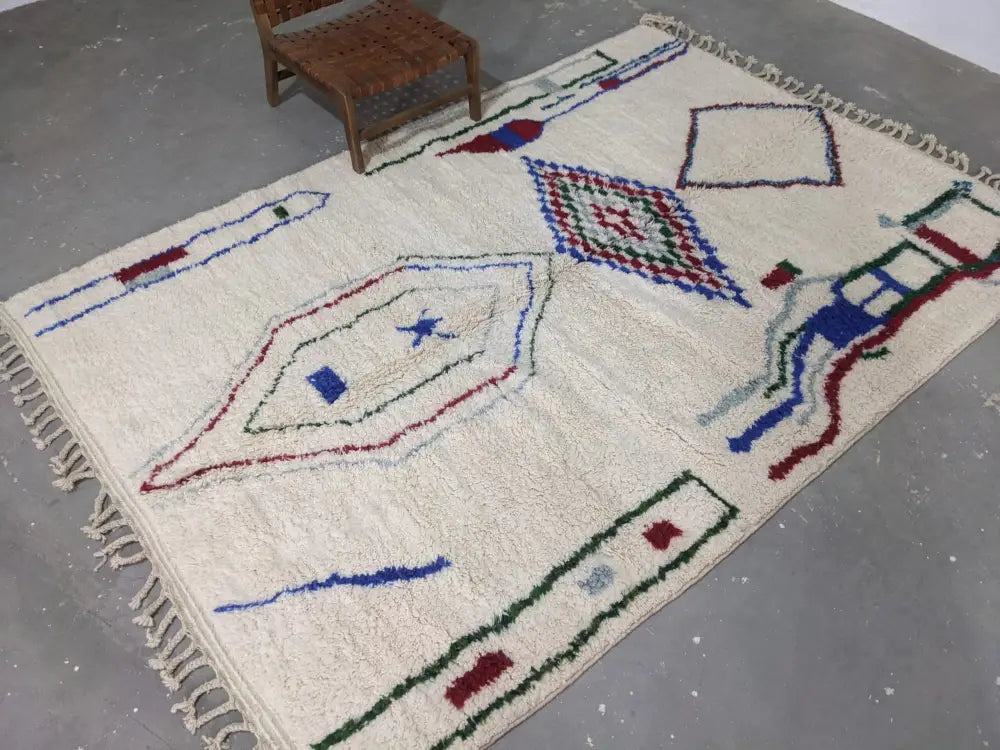 Cream-colored DecorBites™ moroccan handmade traditional azilal rug with red blue green geometric patterns and fringed edges