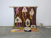 Vibrant multicolored moroccan handmade traditional azilal rug with geometric patterns and textured fringe by decorbites