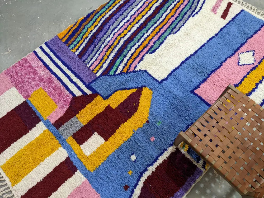 Vibrant moroccan handmade traditional azilal rug with bold geometric patterns in rich blues pinks yellows and purples