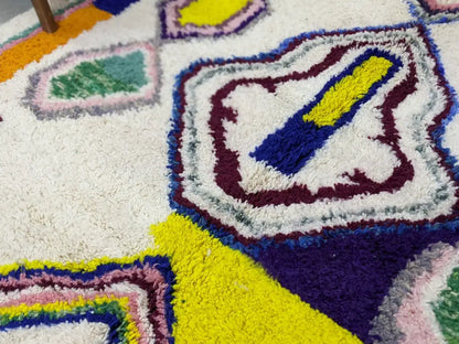 A plush moroccan handmade traditional azilal rug with shaggy texture and vibrant geometric patterns in yellow purple and green