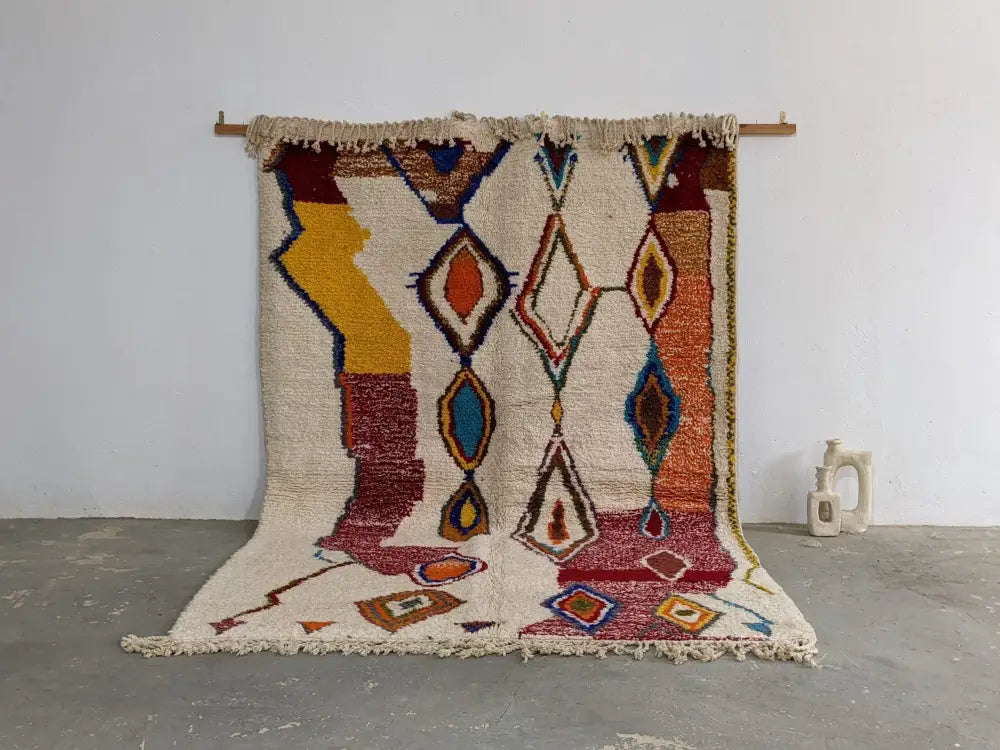 Vibrant moroccan handmade traditional azilal rug with geometric patterns in cream yellow red blue and orange by decorbites