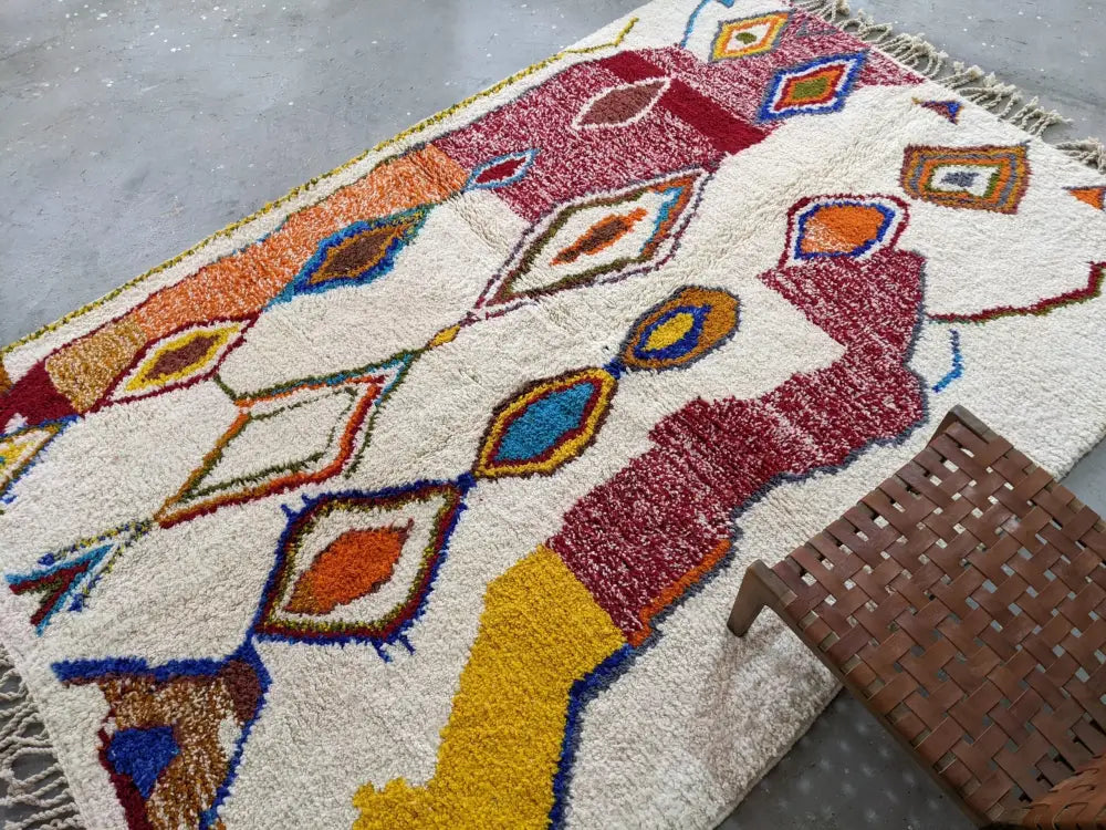 Decorbites™ moroccan handmade traditional azilal rug with plush cream base and bold red, orange, blue, and yellow patterns