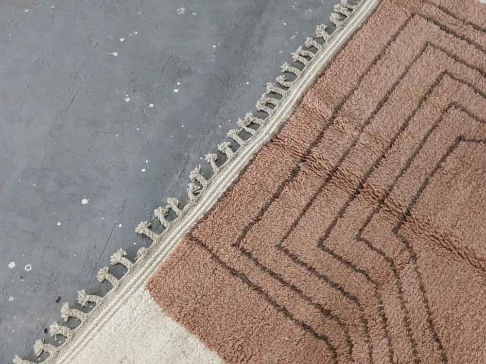 A plush terracotta moroccan handmade traditional azilal rug with a geometric zigzag pattern and cream fringe edge