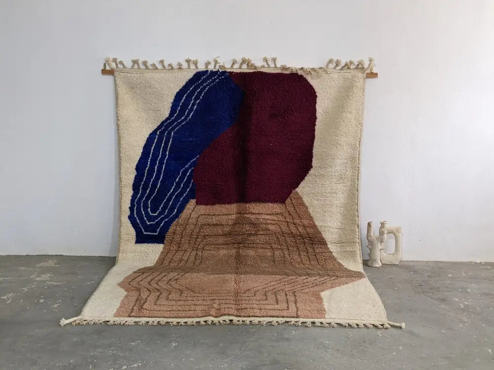 Beige moroccan handmade traditional azilal rug with bold blue and burgundy geometric patterns handwoven wool texture