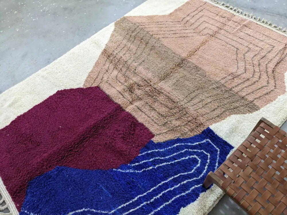 A moroccan handmade traditional azilal rug by decorbites in cream dusty rose burgundy and royal blue wool with geometric pattern