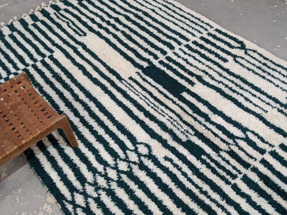 A moroccan handmade traditional azilal rug with bold black and cream stripes in abstract geometric patterns
