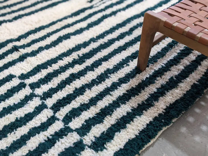 A plush high-pile moroccan handmade traditional azilal rug with bold diagonal deep teal and off-white stripes 316 x 206 cm