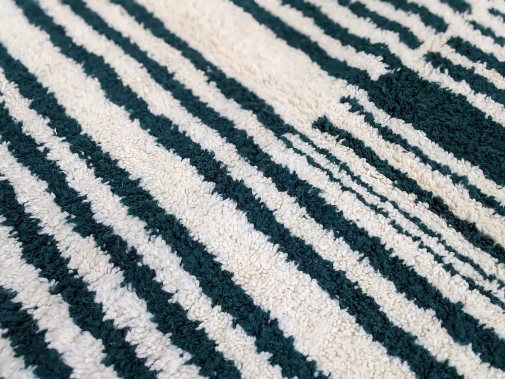 A moroccan handmade traditional azilal rug with plush deep teal and off-white diagonal stripes 316 x 206 cm