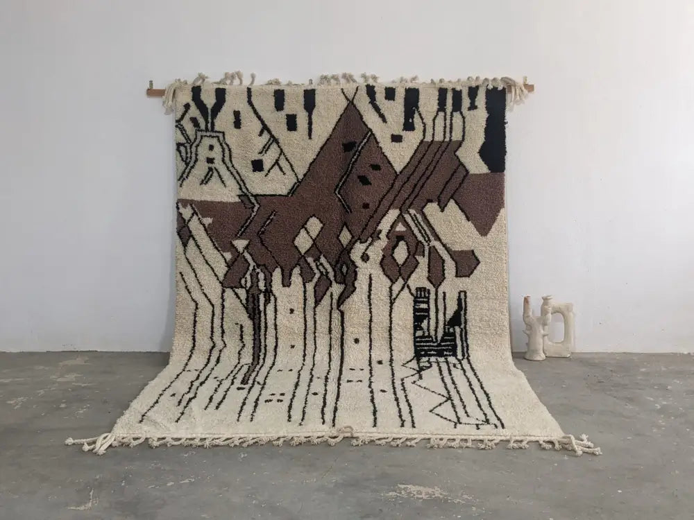 Beige and brown geometric-patterned moroccan handmade traditional azilal rug with black accents and fringed edges by DecorBites