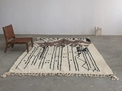 Cream-colored moroccan handmade traditional azilal rug with black and brown geometric patterns and fringed edges