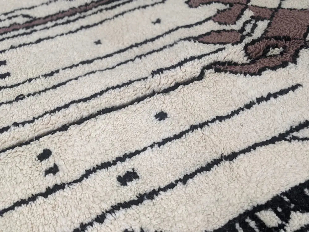 Cream-colored plush wool moroccan handmade traditional azilal rug with bold black and brown geometric patterns