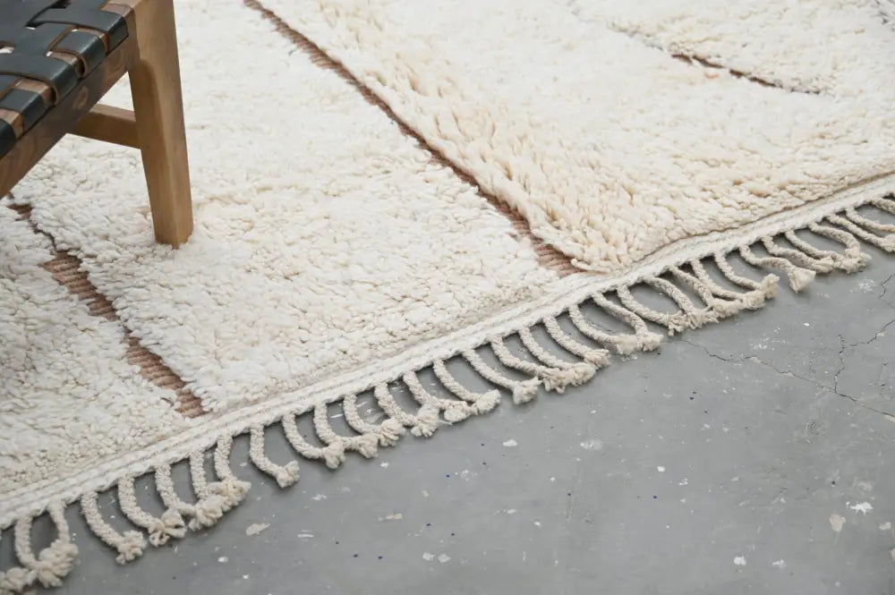 Cream-colored plush wool beni ouarain rug with textured surface and long fringe in moroccan handmade style