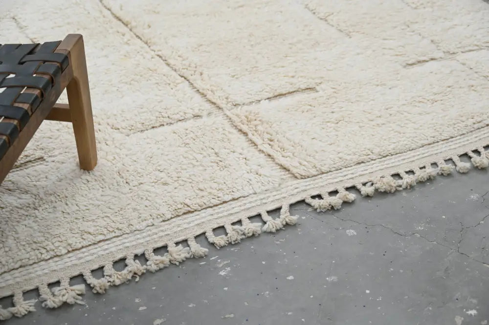 Cream-colored plush wool beni ouarain carpet with textured surface and decorative tassels moroccan handmade rug