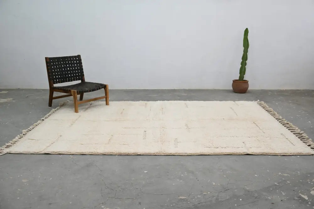Cream-colored beni ouarain carpet with minimalist geometric pattern and fringed edges moroccan handmade wool rug
