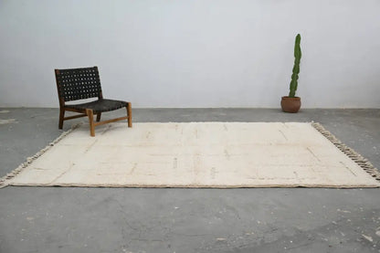 Cream-colored beni ouarain carpet with minimalist geometric pattern and fringed edges moroccan handmade wool rug