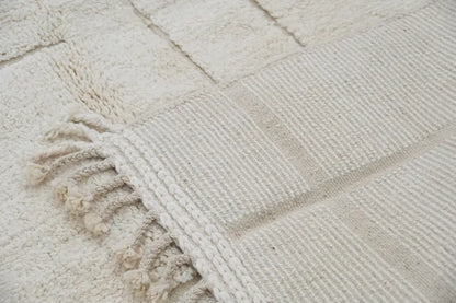 Off-white moroccan handmade beni ouarain carpet with textured surface and fringed edges by DecorBites™ 305 x 202 cm