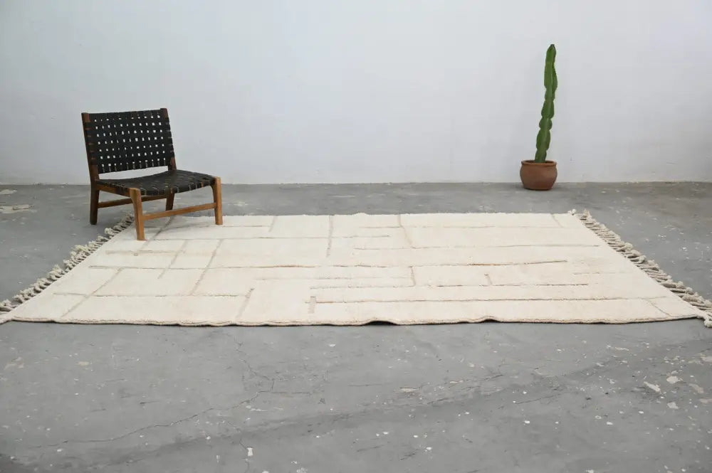 Cream-colored beni ouarain carpet with a geometric pattern and fringed edges moroccan handmade wool rug