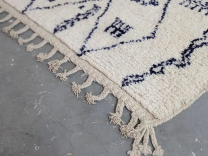 Cream-colored moroccan handmade beni ouarain rug with navy blue geometric patterns and fringed edges 244 x 157 cm