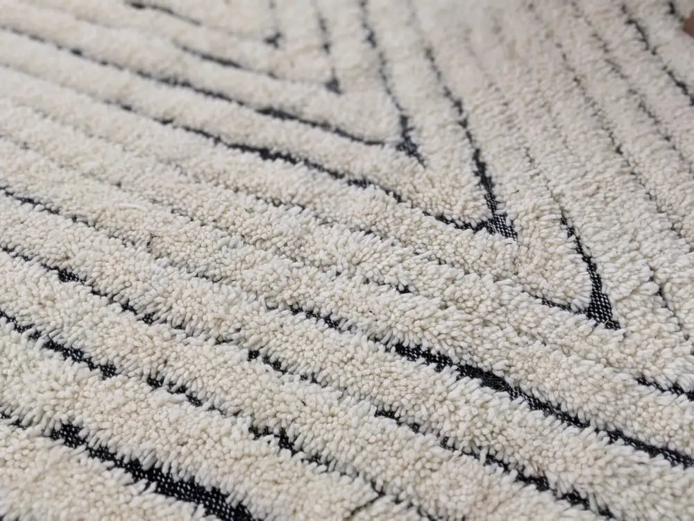 Cream-colored beni ouarain rug with plush textured surface and bold black geometric stripes moroccan handmade decor