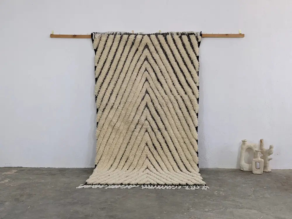 Cream-colored textured wool beni ouarain rug with bold black zigzag stripes and fringed edges moroccan handmade