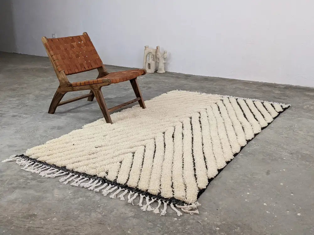 Cream-colored textured wool beni ouarain rug with black diagonal stripes and white fringe moroccan handmade traditional design