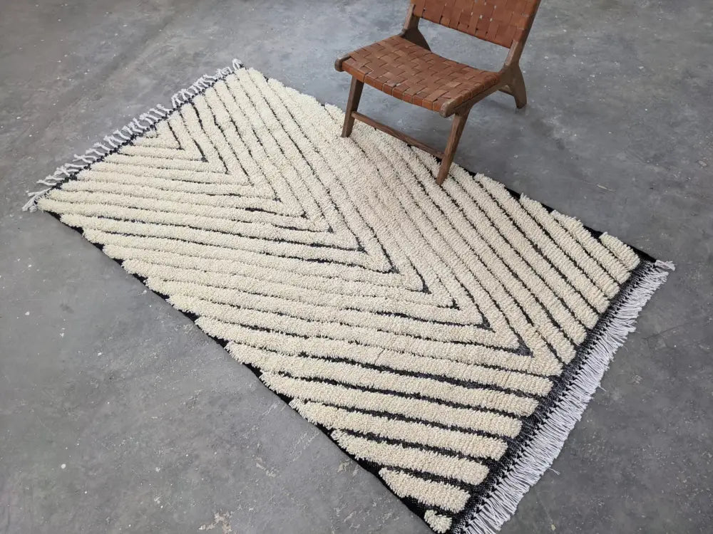 Creamb-colored textured beni ouarain rug with bold black chevron stripes and white fringe edges moroccan handmade