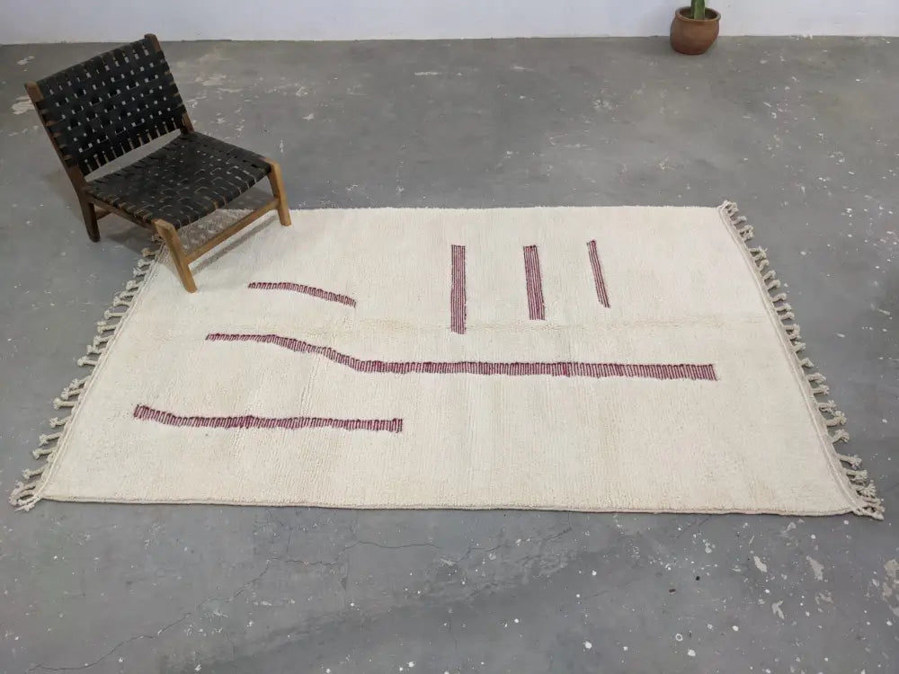 Cream-colored moroccan handmade beni ouarain rug with red geometric patterns and fringed edges 258 x 164 cm