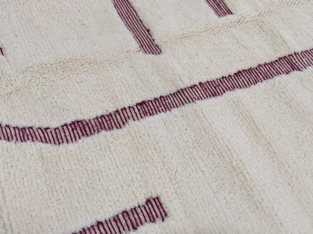 Cream-colored moroccan handmade beni ouarain rug with bold maroon geometric stripes 258 x 164 cm by DecorBites