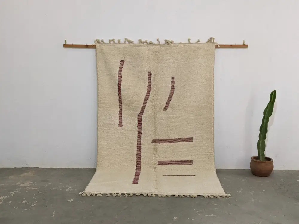 Beige woven moroccan handmade beni ouarain rug with rust geometric patterns and fringed edges 258 x 164 cm