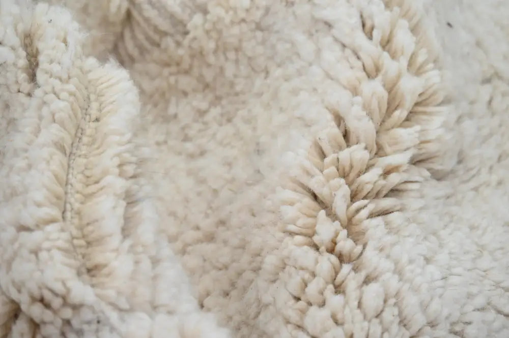 Cream-colored plush fleece fabric with soft texture and stitching on moroccan handmade beni ouarain rug back side