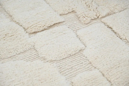 Cream-colored moroccan handmade beni ouarain rug with plush textured patchwork design and ribbed borders 285 x 210 cm
