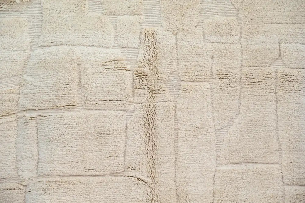 Beige textured beni ouarain rug with woven blocky pattern and visible wear along center seam moroccan handmade