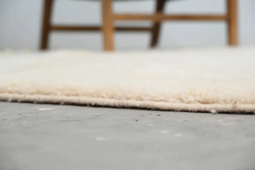 Cream-colored plush moroccan handmade beni ouarain rug with soft textured surface and neatly finished edges