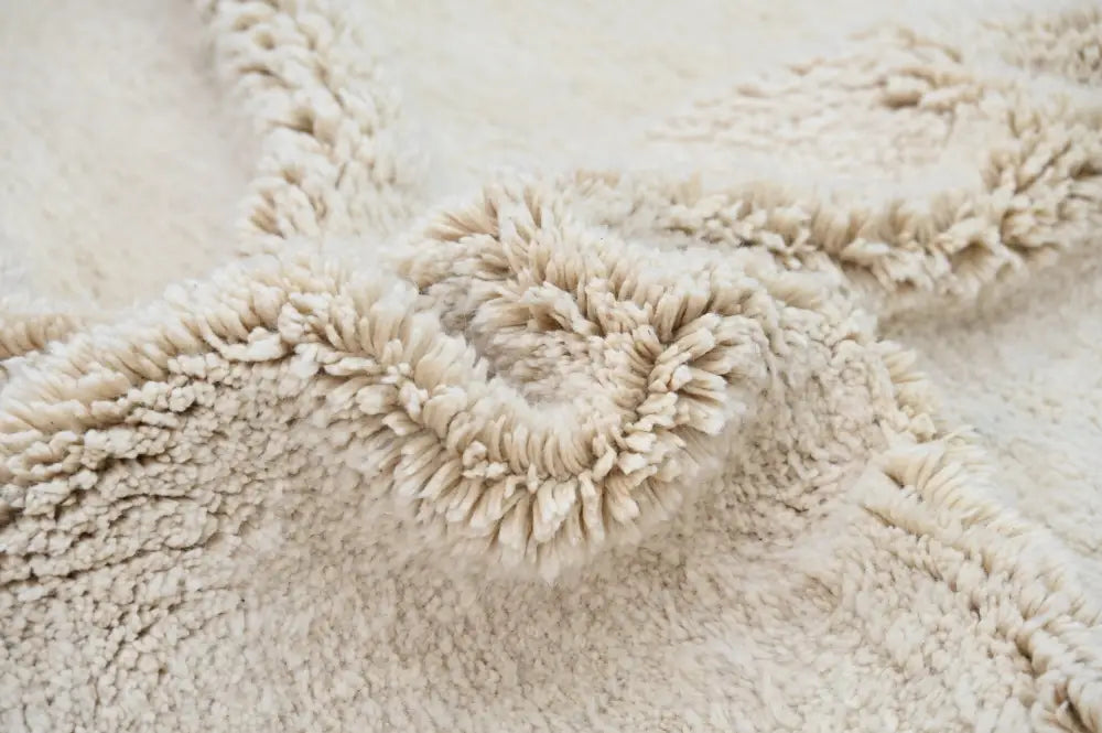 Cream-colored plush fleece beni ouarain rug with soft textured surface and slightly frayed edges moroccan handmade