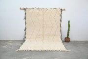 Cream-colored moroccan handmade beni ouarain rug with textured handwoven surface and bold zigzag pattern natural tones