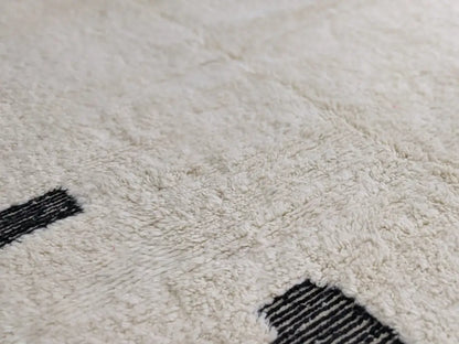 Cream-colored beni ouarain rug with bold black geometric stripes made from plush wool moroccan handmade design
