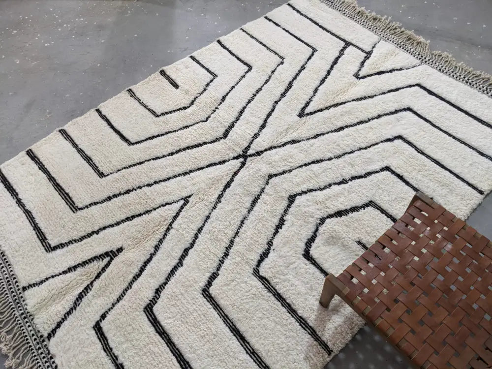 Cream-colored beni ouarain rug with bold black geometric patterns and fringed edges moroccan handmade traditional design