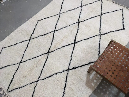 Cream-colored moroccan handmade beni ouarain rug with bold black geometric diamond pattern and fringed edges 292 x 202 cm