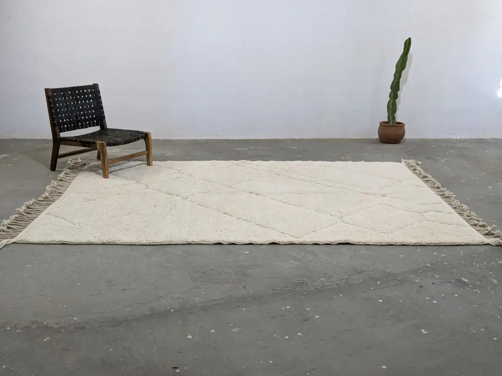 Cream-colored moroccan handmade beni ouarain rug with diamond pattern and fringed edges 295 x 214 cm by DecorBites