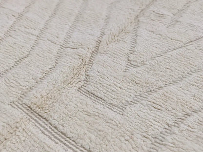 Cream-colored plush bath towel with textured looped pile and gray geometric stripes featured with beni ouarain rug