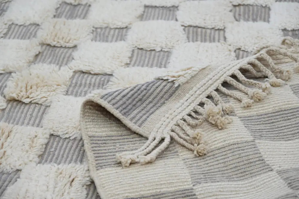 Cream and gray checkered beni ouarain rug with textured fringed edges in a 300 x 203 cm traditional design