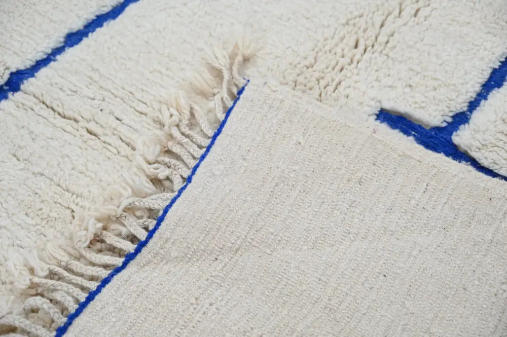 Cream-colored moroccan handmade beni ouarain rug with thick wool and bold blue geometric borders 300 x 207 cm