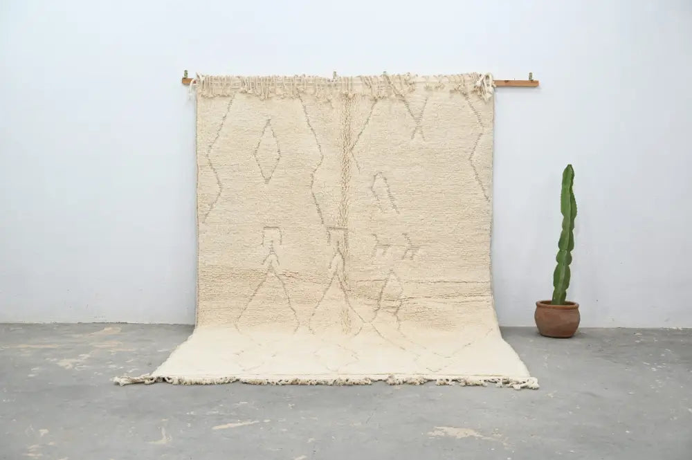 Cream-colored moroccan handmade beni ouarain rug with textured surface and geometric patterns 300 x 208 cm by decorbites