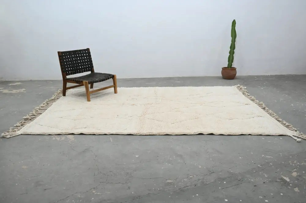 Cream-colored moroccan handmade beni ouarain rug with fringed edges and subtle geometric patterns 300 x 208 cm